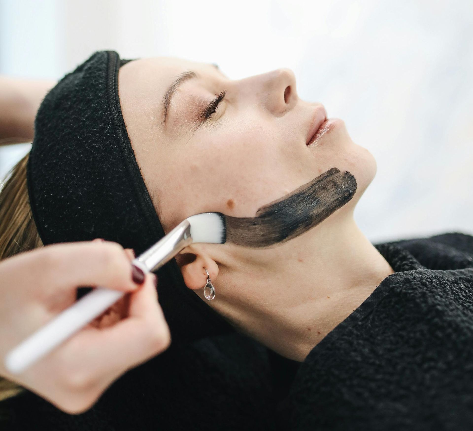 Una mujer está recibiendo un tratamiento facial con un cepillo.
