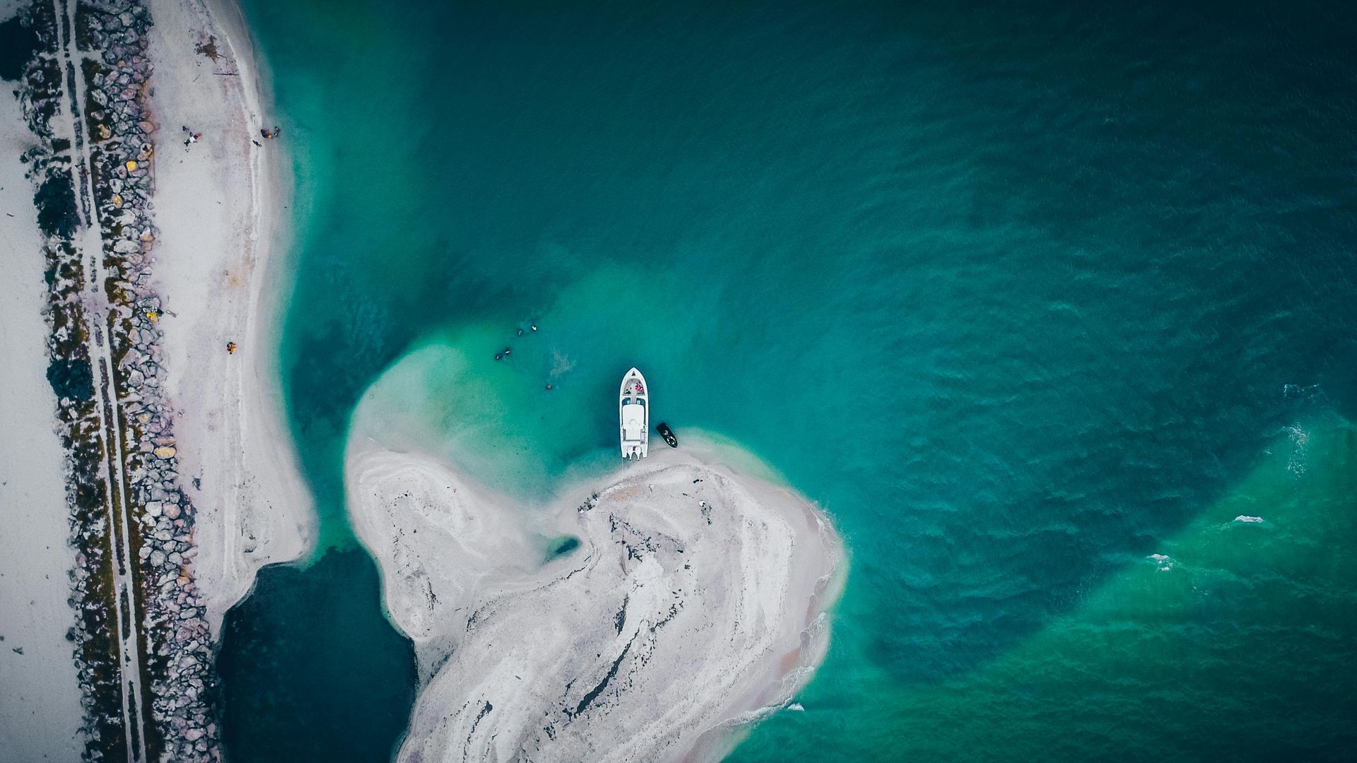 Una vista aérea de una persona parada en una pequeña isla en medio de un lago.