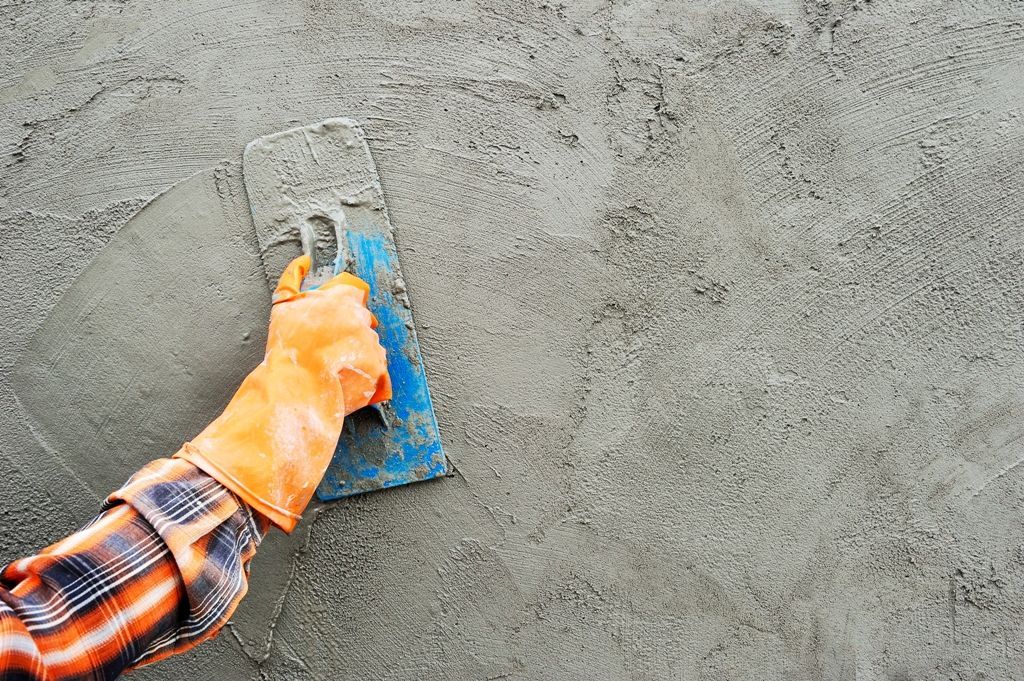 Skilled worker meticulously smoothing plaster on a wall, creating a smooth and even surface for painting or finishing.