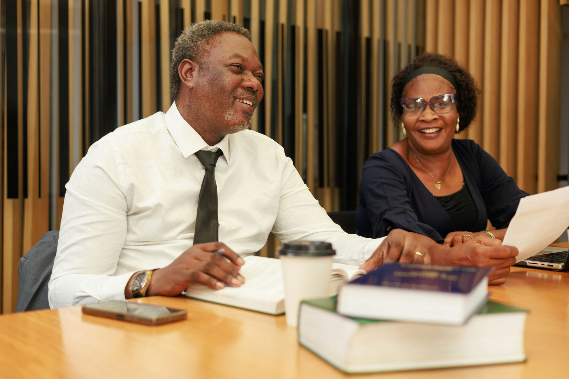 A man with a backpack is standing next to a lake in the woods.