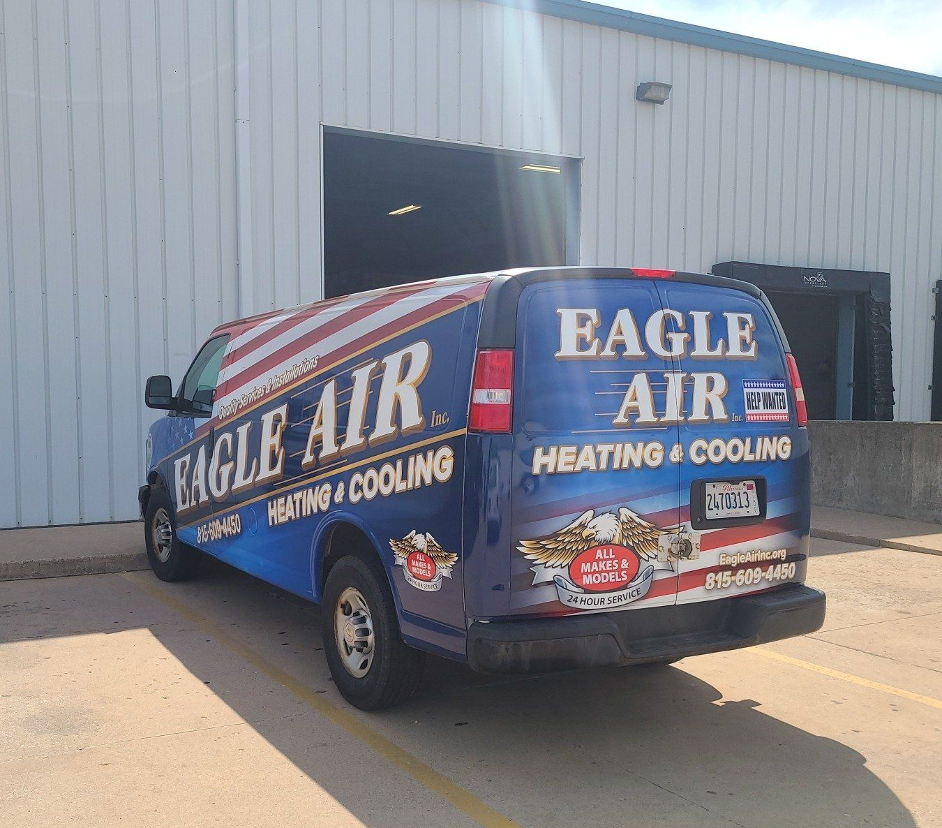 Blue Eagle Air heating and cooling van parked outside a warehouse, with American flag graphics.