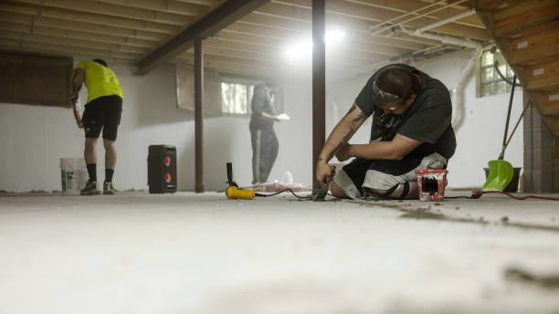 A basement waterproofing contractor team performing waterproofing services on a home foundation
