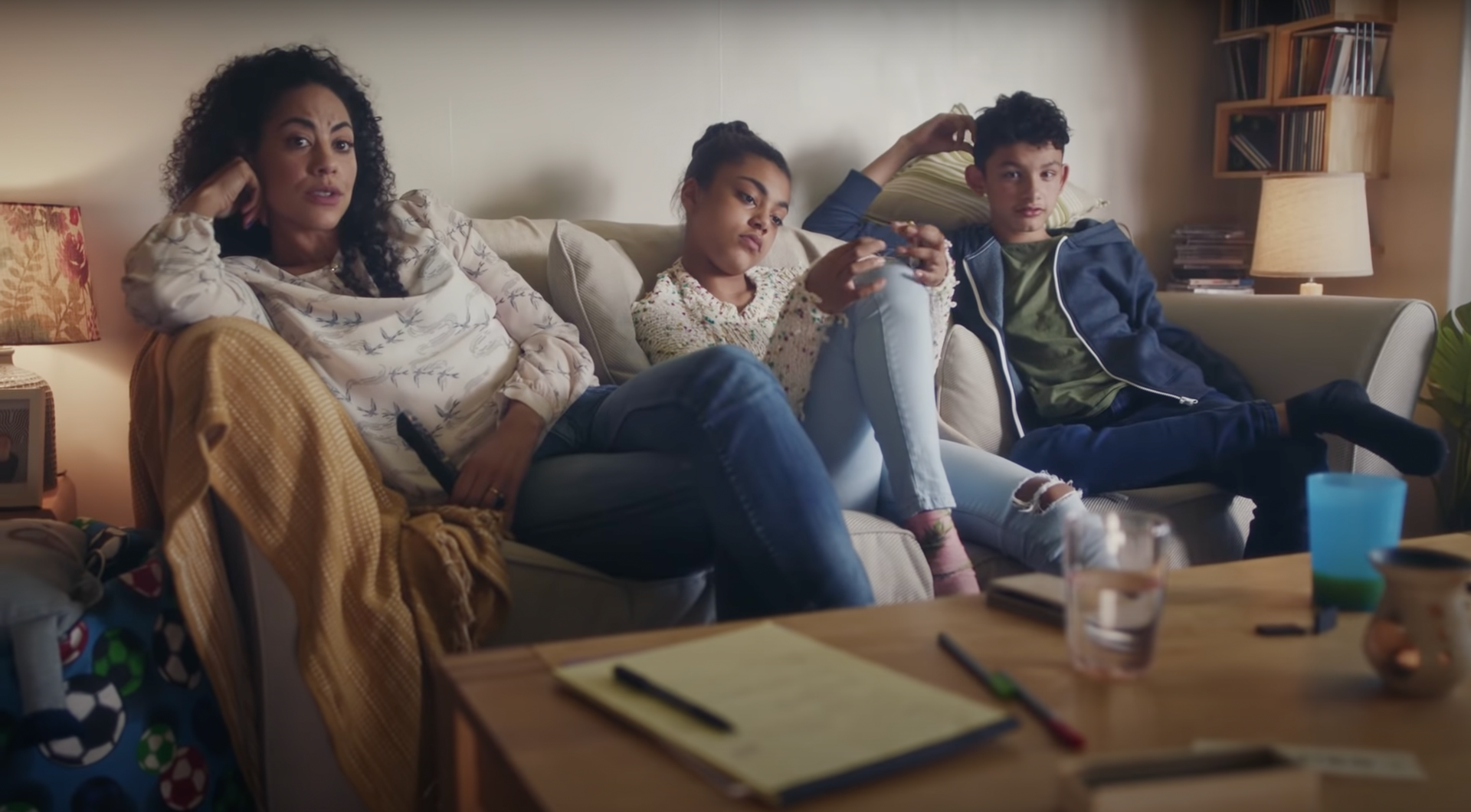 A group of people are sitting on a couch playing a video game.