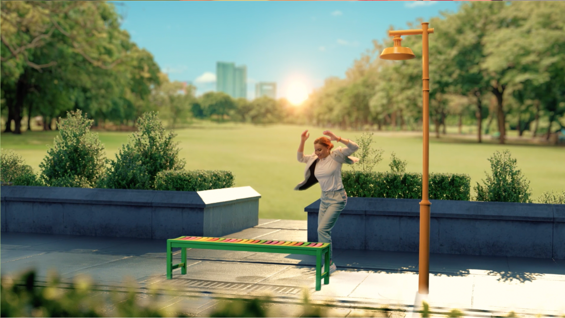 A man is standing on a bench in a park.