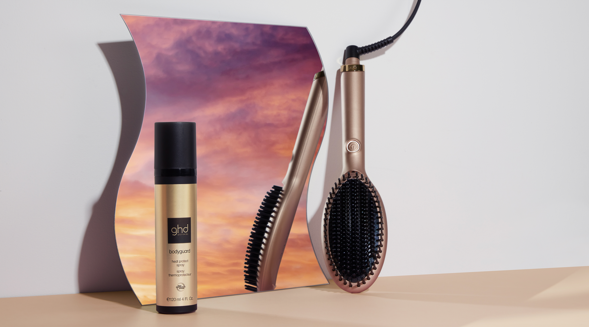 a hair dryer , brush and spray are on a table .