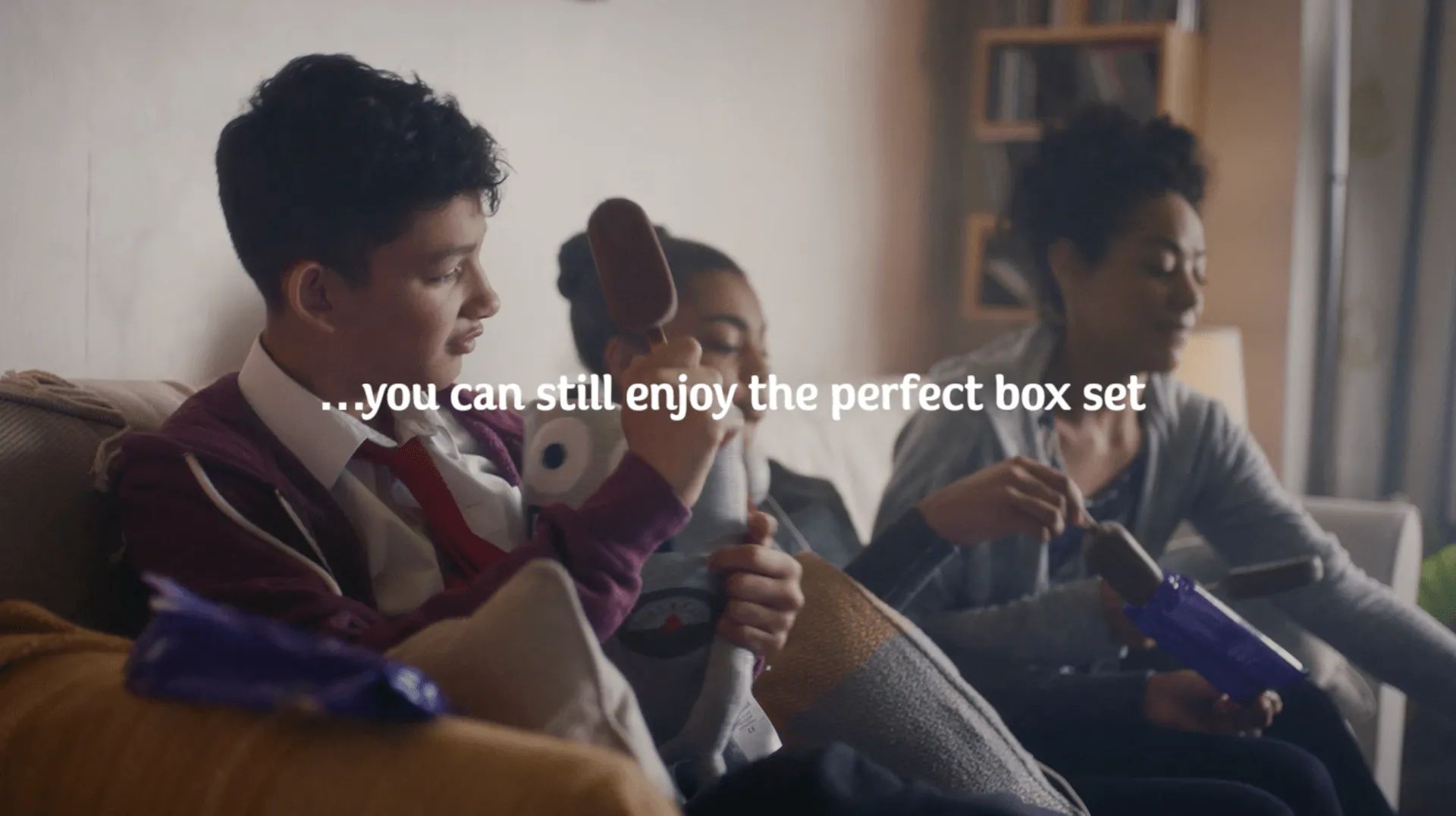 A group of people are sitting on a couch playing a video game.