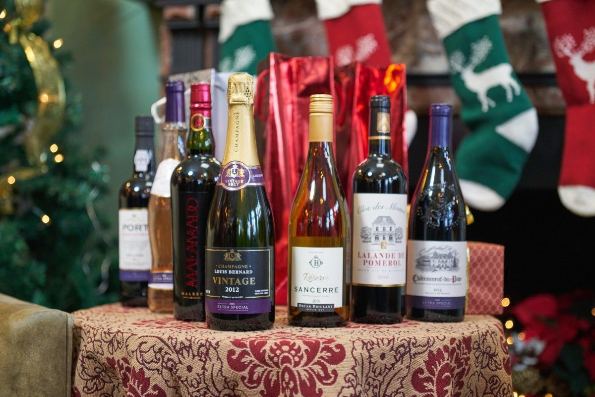 A group of wine bottles sitting on top of a table next to christmas stockings.