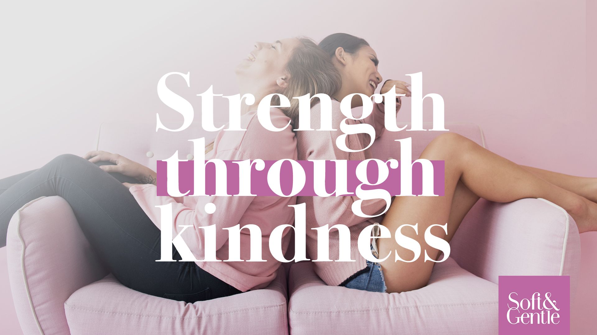 Two women are sitting next to each other on a pink couch.