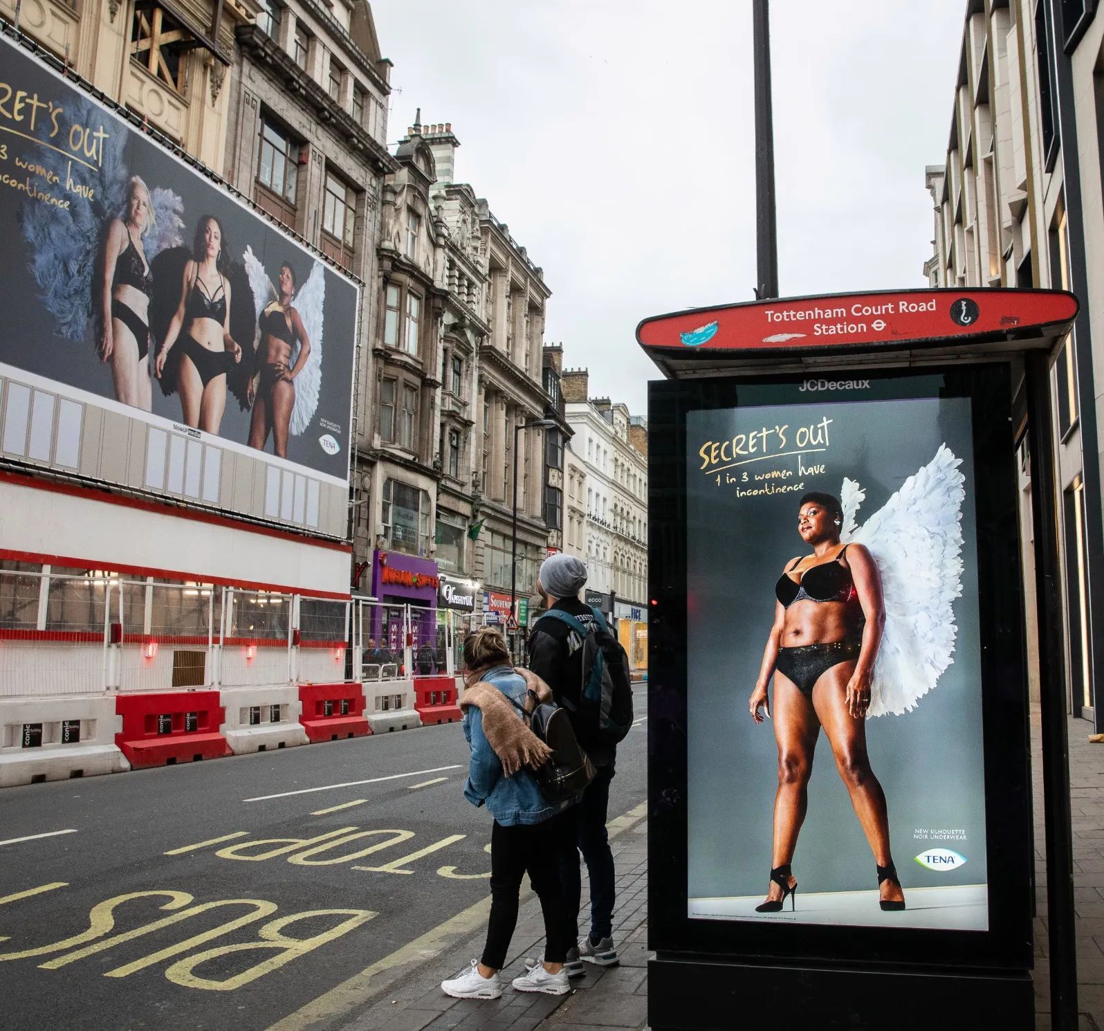 A bus stop with a victoria 's secret ad on it