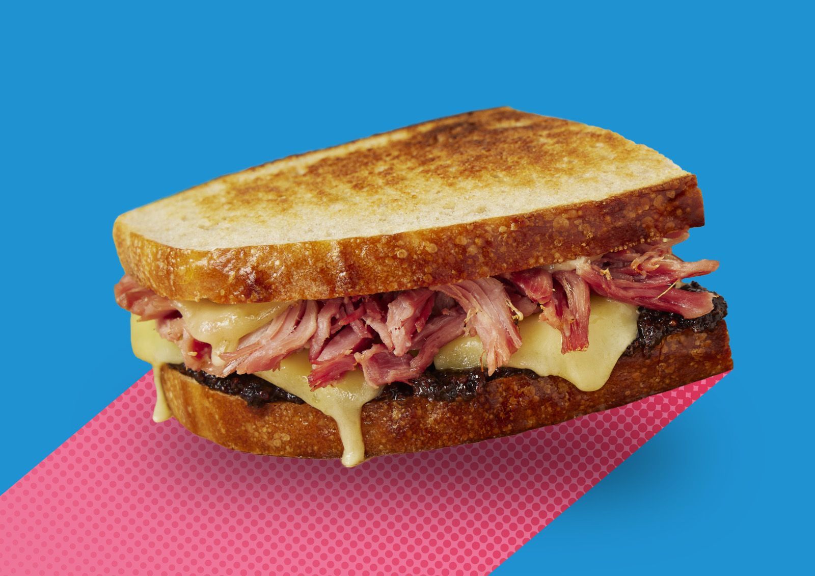 A man is standing in front of a rack of bread in a bakery.