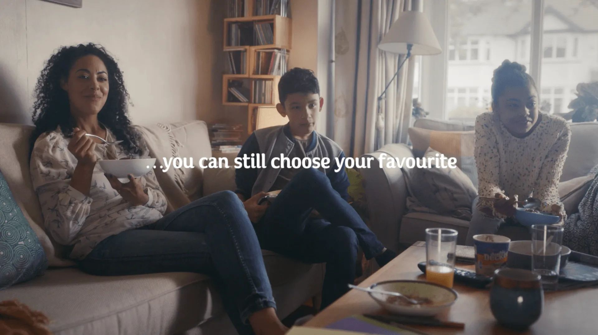 A group of people are sitting on a couch playing a video game.