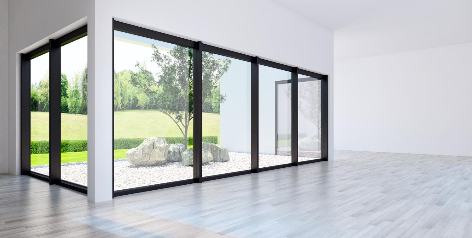 Modern interior with large sliding glass doors overlooking a garden. Bright, neutral colors.