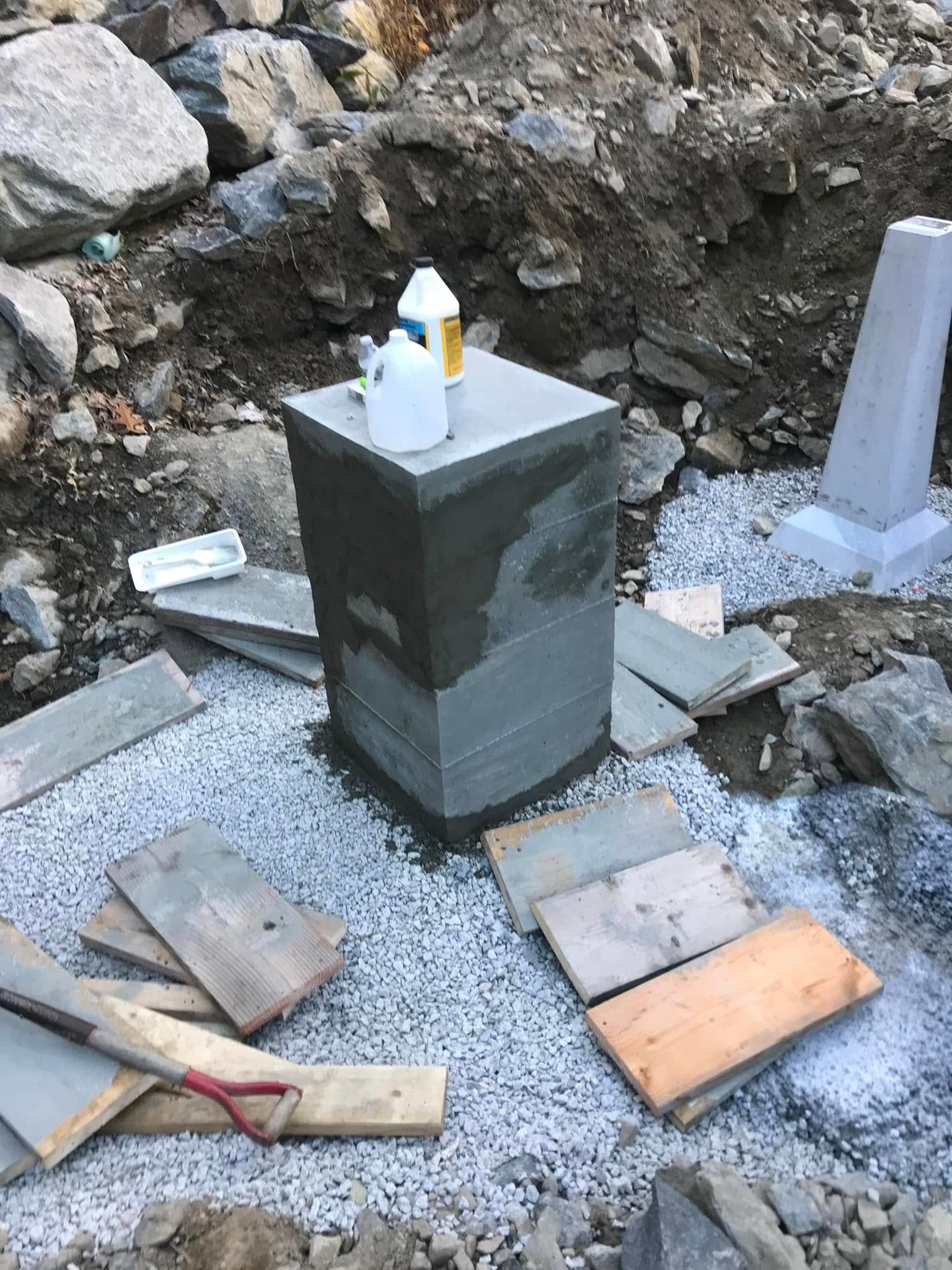 Woman in straw hat smiles, holding wine glass near a lake.