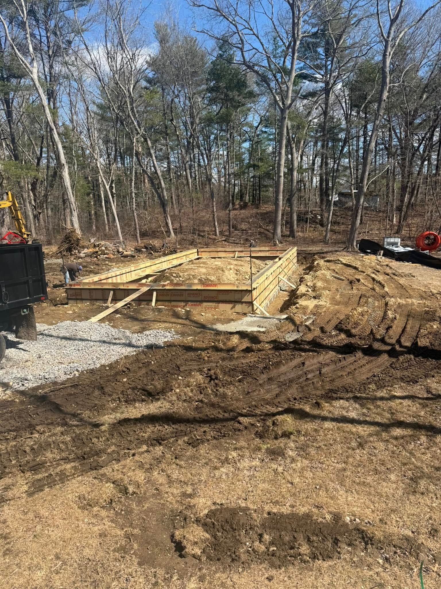 Woman in straw hat smiles, holding wine glass near a lake.