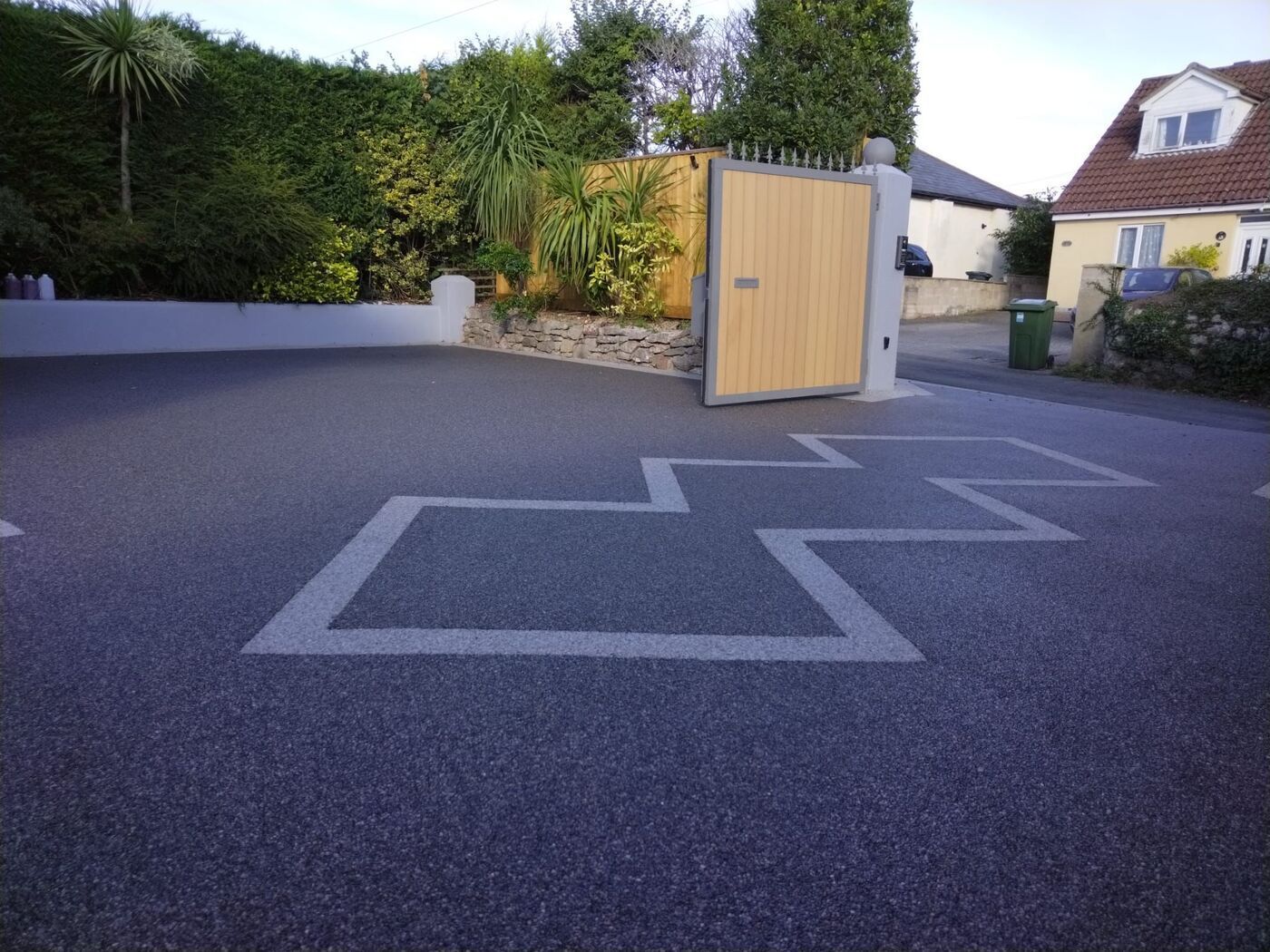 Dark resin driveway with a light grey pattern on it