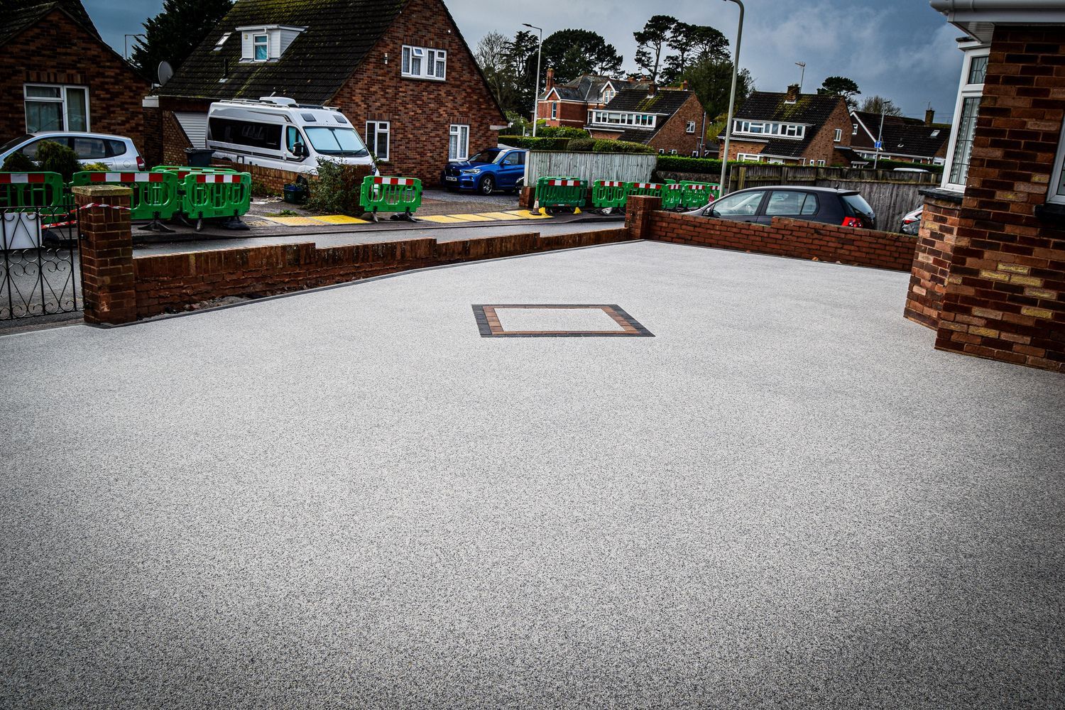 Grey resin driveway with a block paving pattern on it