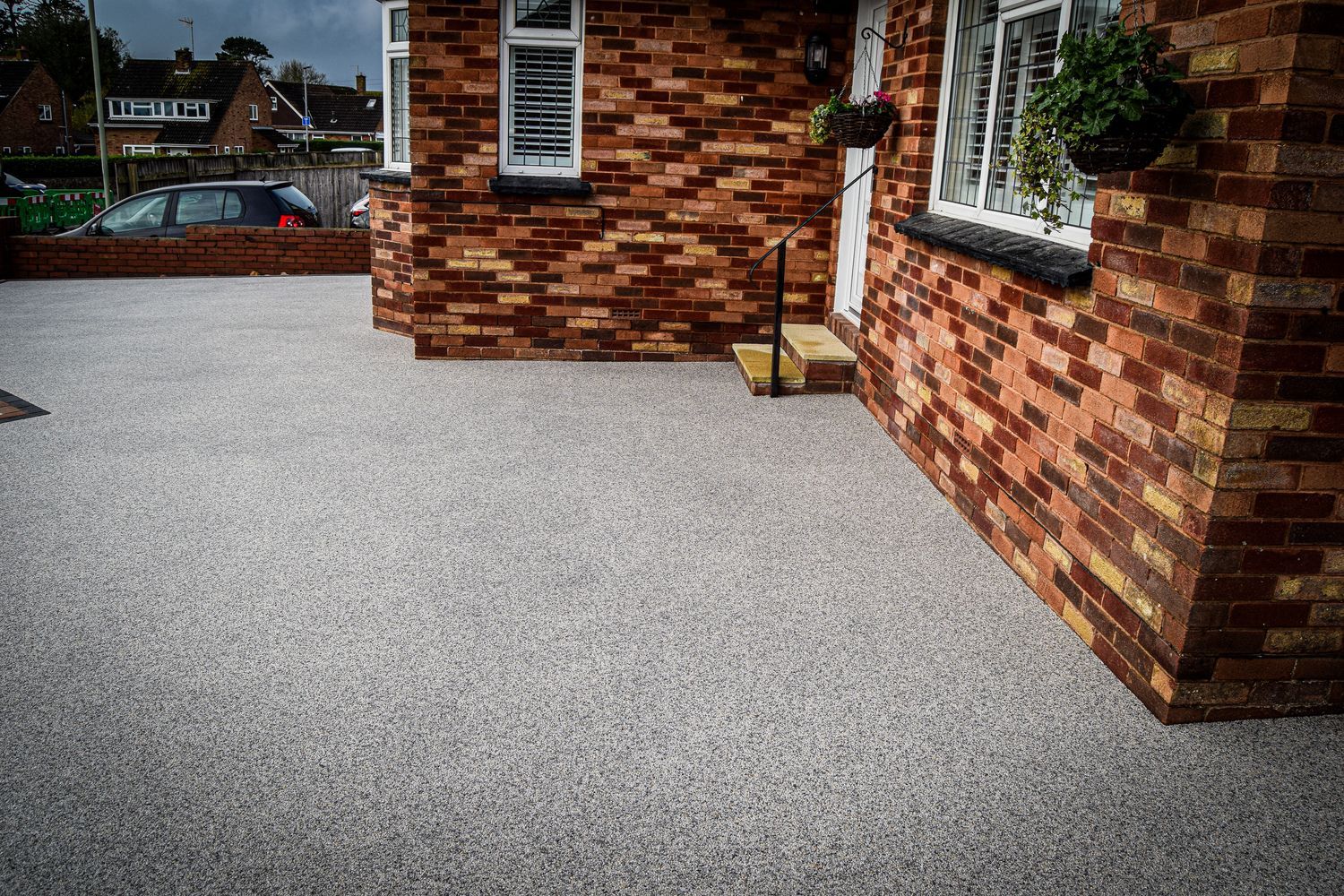 Grey resin driveway outside a home