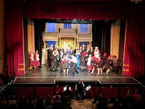 A group of people are dancing on a stage in front of a crowd.