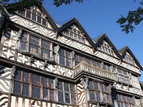 A large building with a lot of windows and a blue sky in the background.