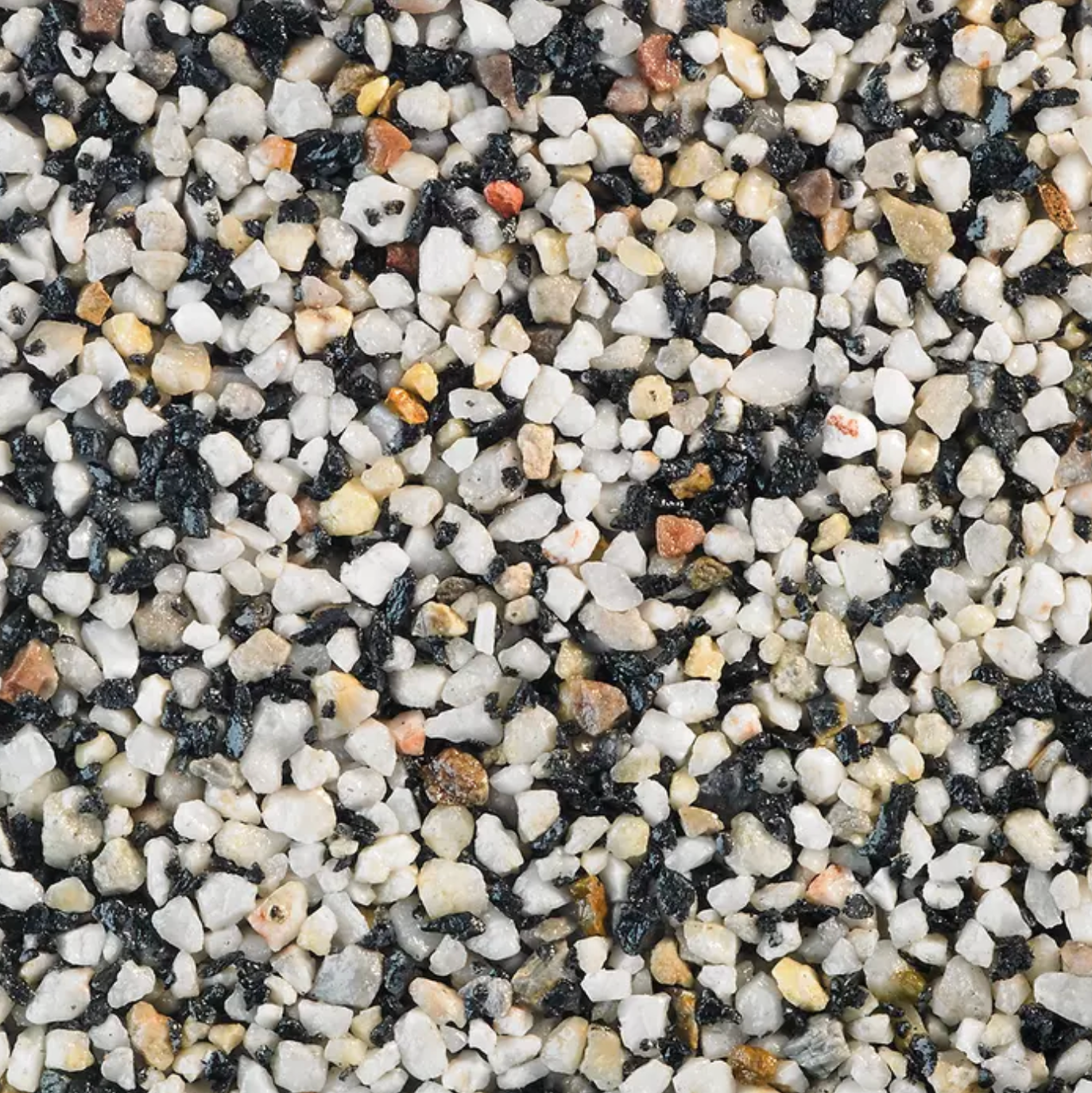 Close-up of a speckled, textured surface of white, black, beige, and reddish-brown small stones.