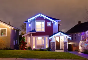 A house with christmas lights on it is lit up at night