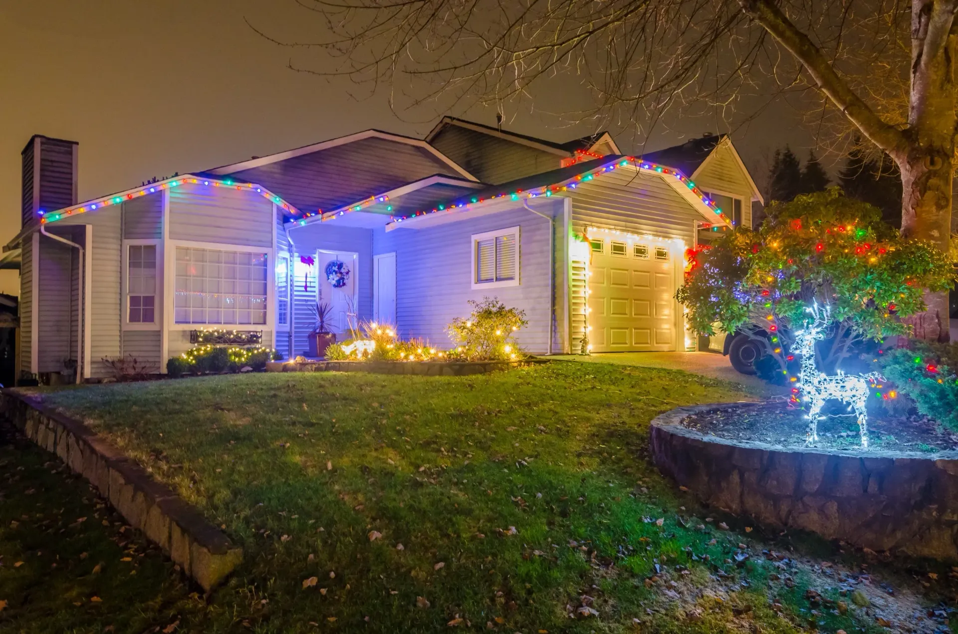 A house with christmas lights on it is lit up at night