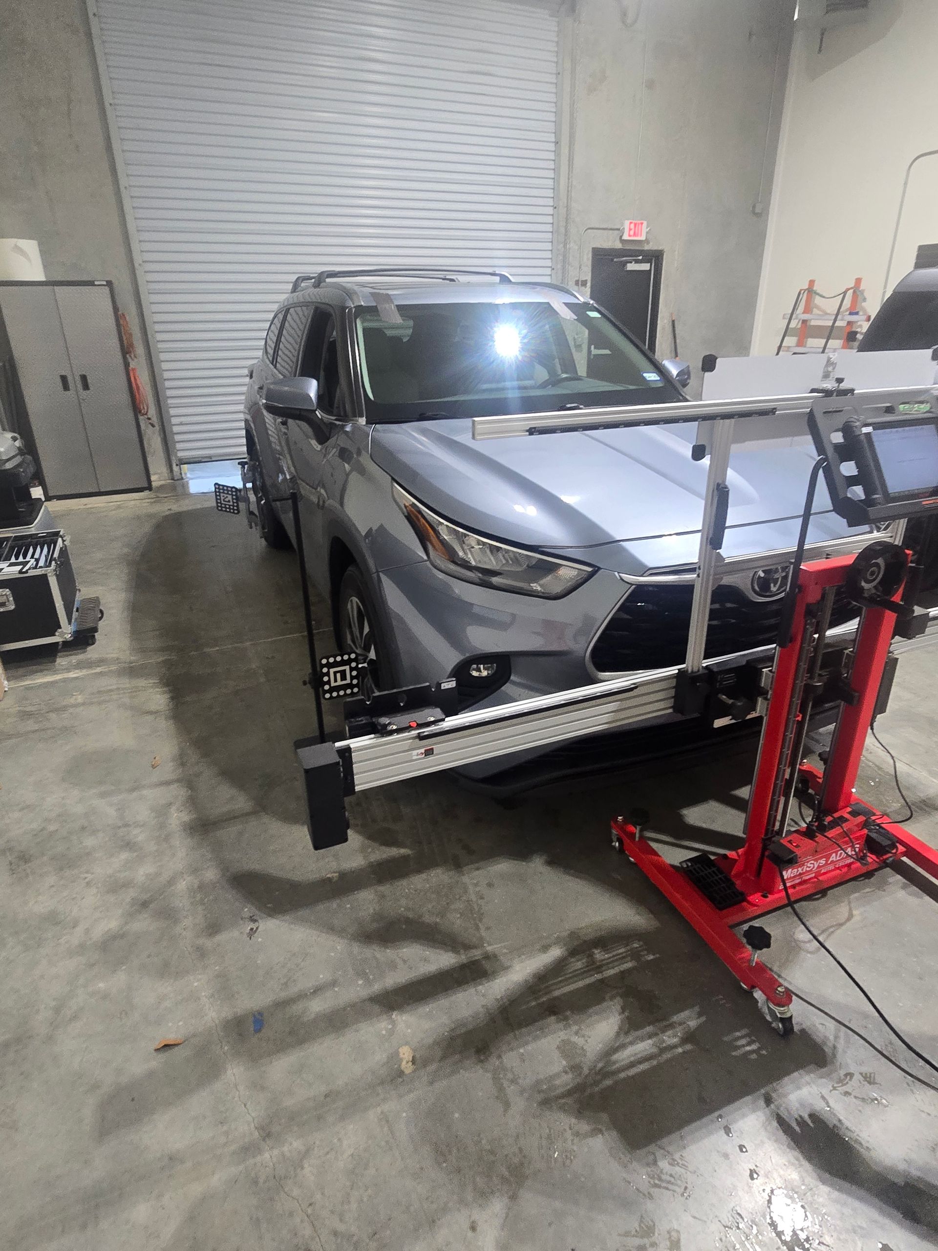 A car is sitting on a lift in a garage.
