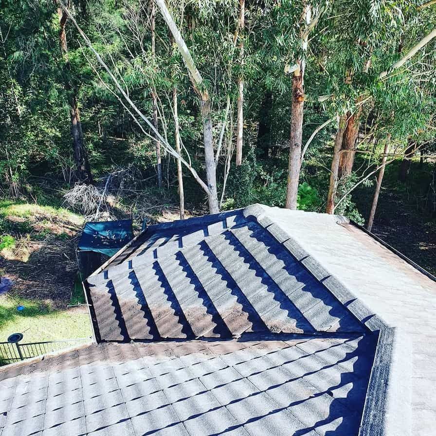 A Roof With a Lot of Tiles on It and Trees in the Background — TK Guttercleaning in Hamlyn Terrace, NSW