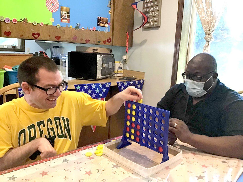 Employee playing connect four with happy client.