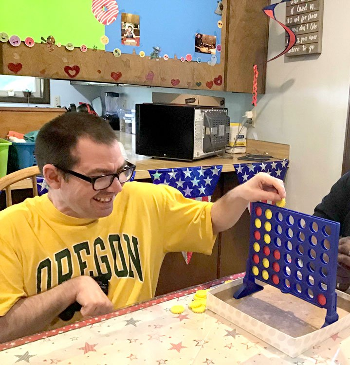Employee playing connect four with happy client.
