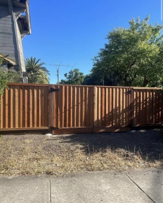 a white picket fence surrounds a lush green yard .