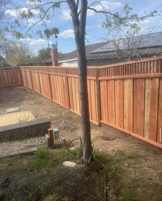 a man is using a drill to install a fence .