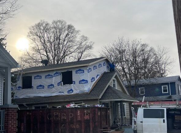 A white van is parked in front of a house under construction.