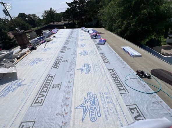 A roof is being covered with a sheet of paper that says evergreen