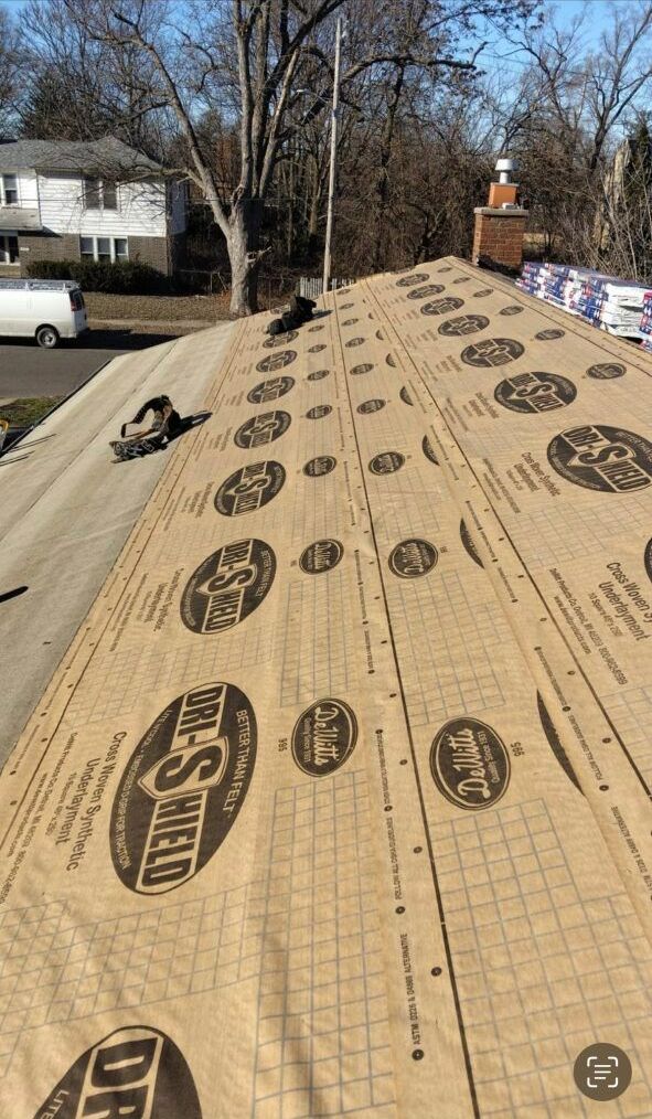 A roof is being covered with a piece of paper.