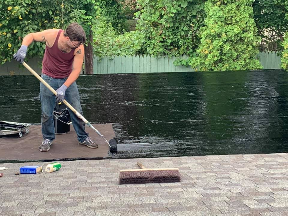 Man Applying Paint On The Roofing — Redford, MI — Bill's Home Maintenance