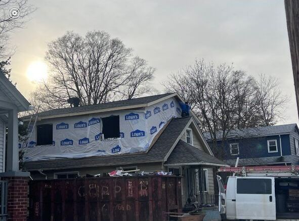 A white van is parked in front of a house under construction.