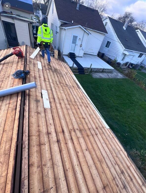A man is standing on top of a wooden roof.