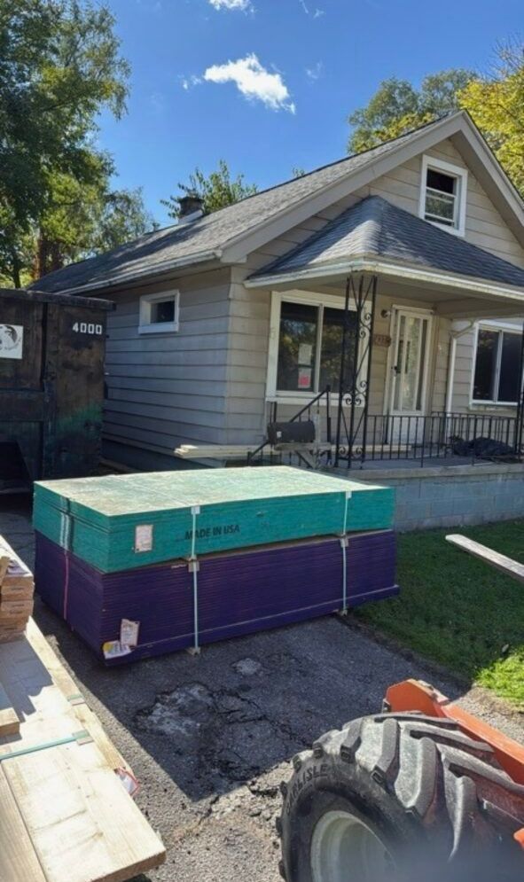 A purple box is sitting in front of a house.