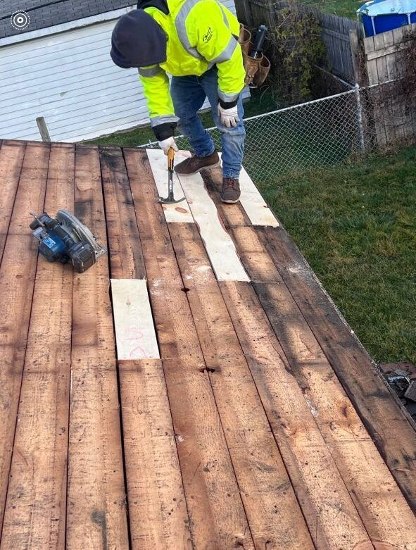 A man is working on the roof of a house.