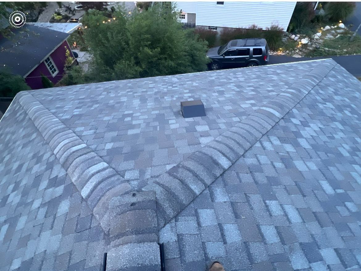 A person is standing on the roof of a house.