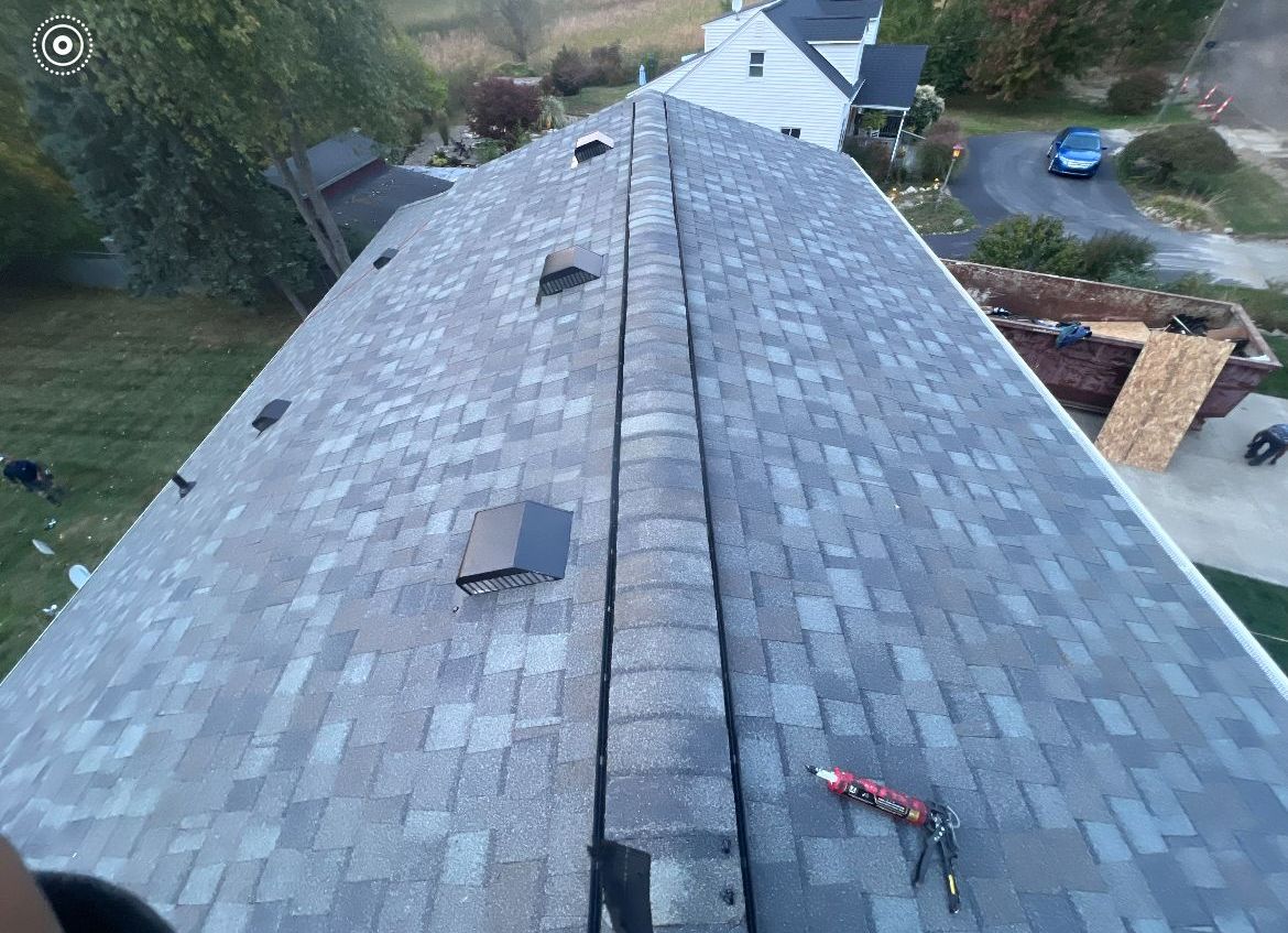 An aerial view of a roof with shingles being installed.