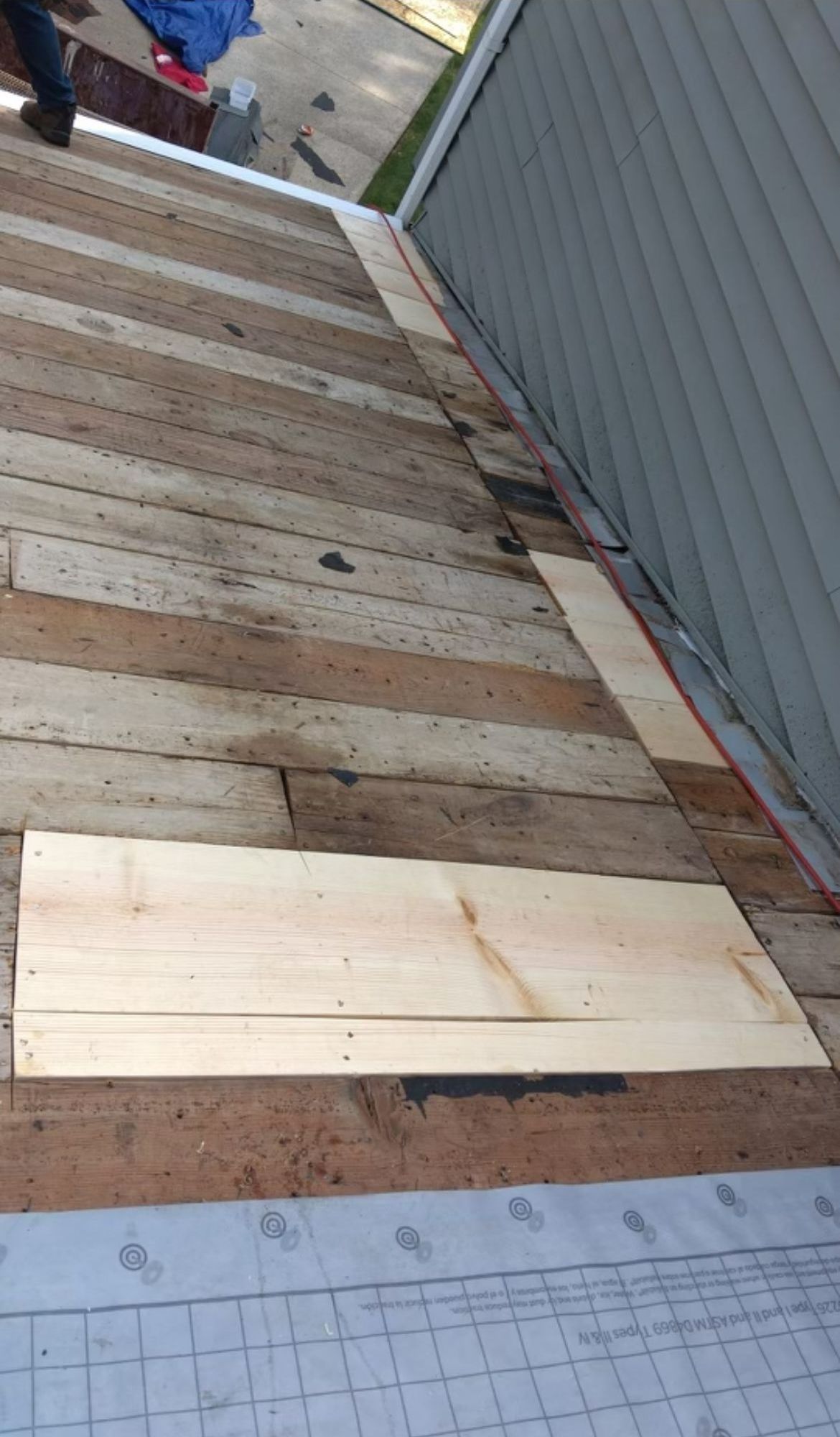 A piece of wood is sitting on top of a wooden roof.