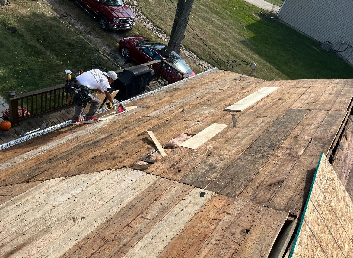 A man is working on the roof of a house.