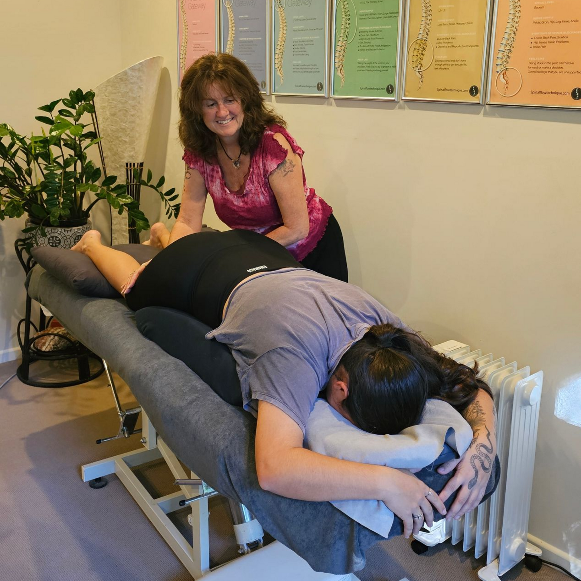 Massage therapist working on a client on a table in a treatment room