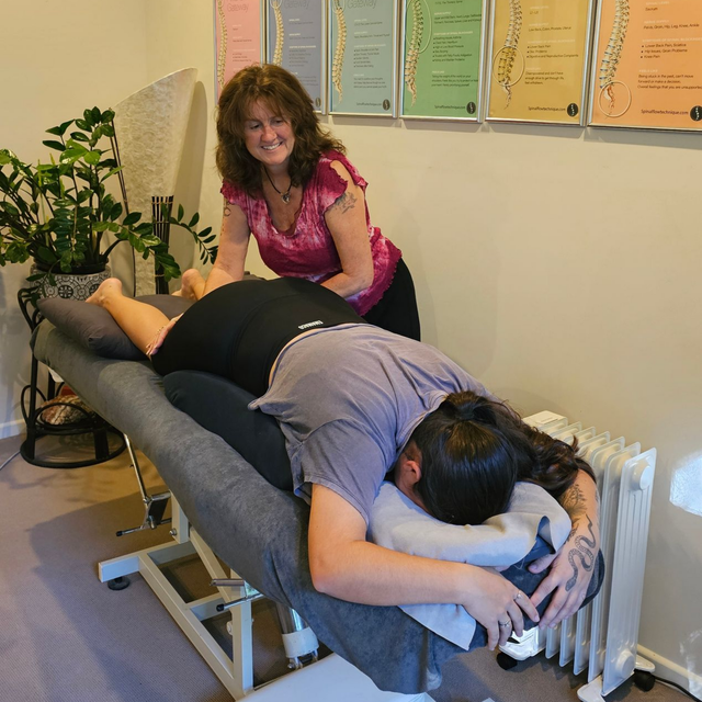 Massage therapist working on a client on a table in a treatment room