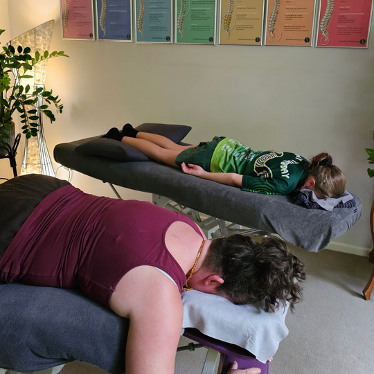 Two people lying face down on massage tables in a calm spa room