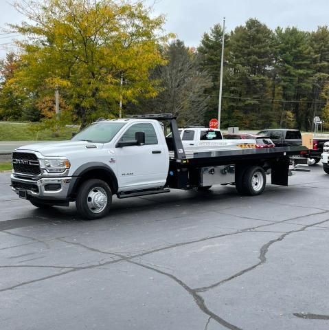 A white tow truck is parked in a parking lot.