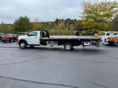 A white tow truck is parked in a parking lot.
