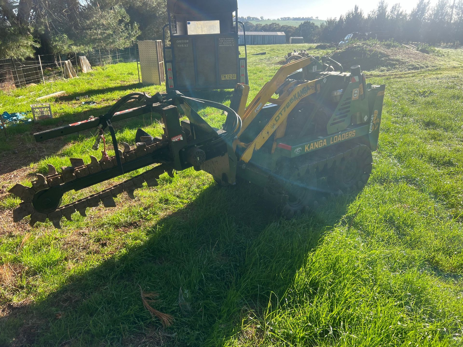 A yellow and black tractor is parked in a grassy field